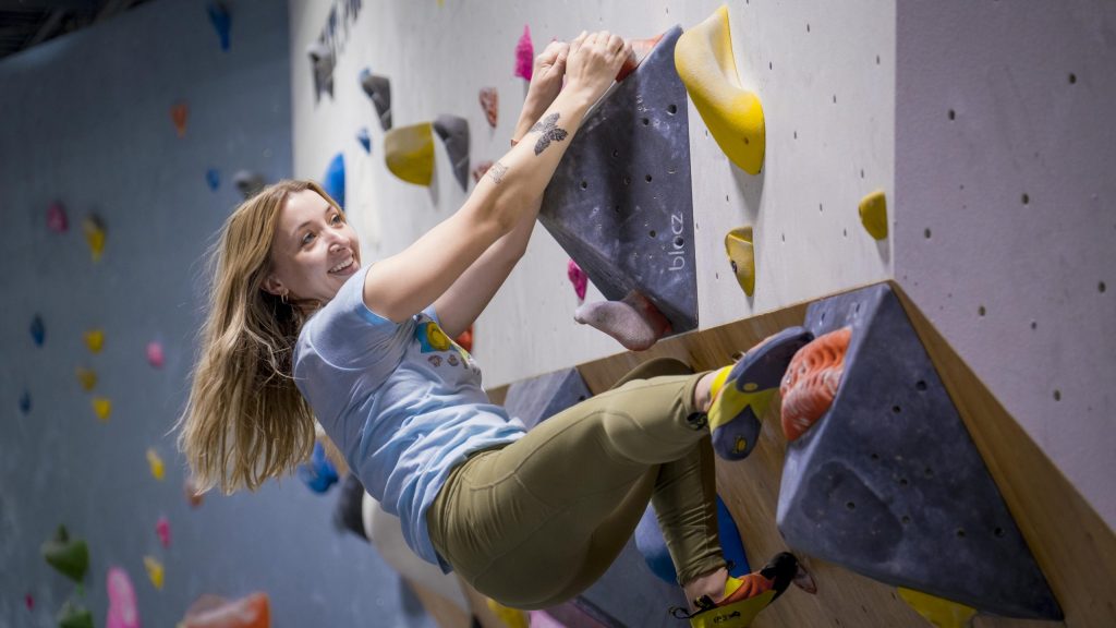 A smiling climber on the bouldering wall