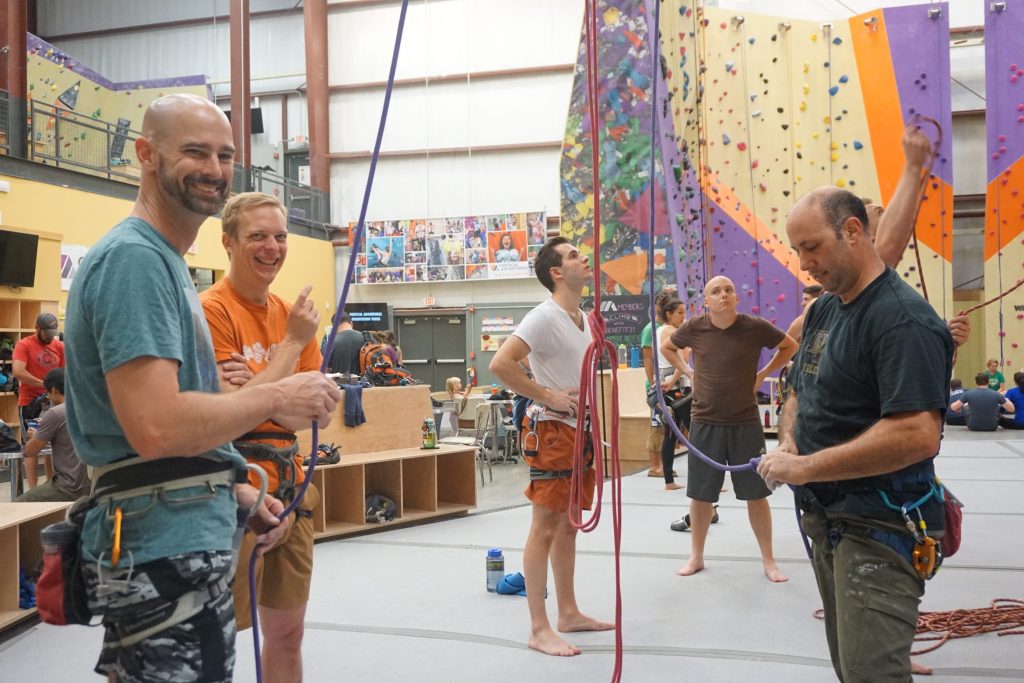 Friends laughing together while belaying