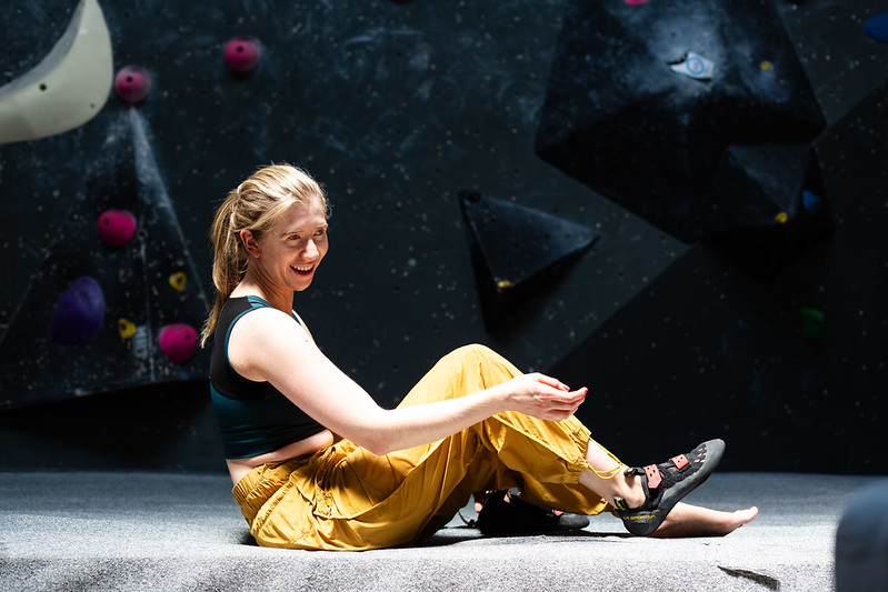 Climber smiling while resting on the bouldering mats
